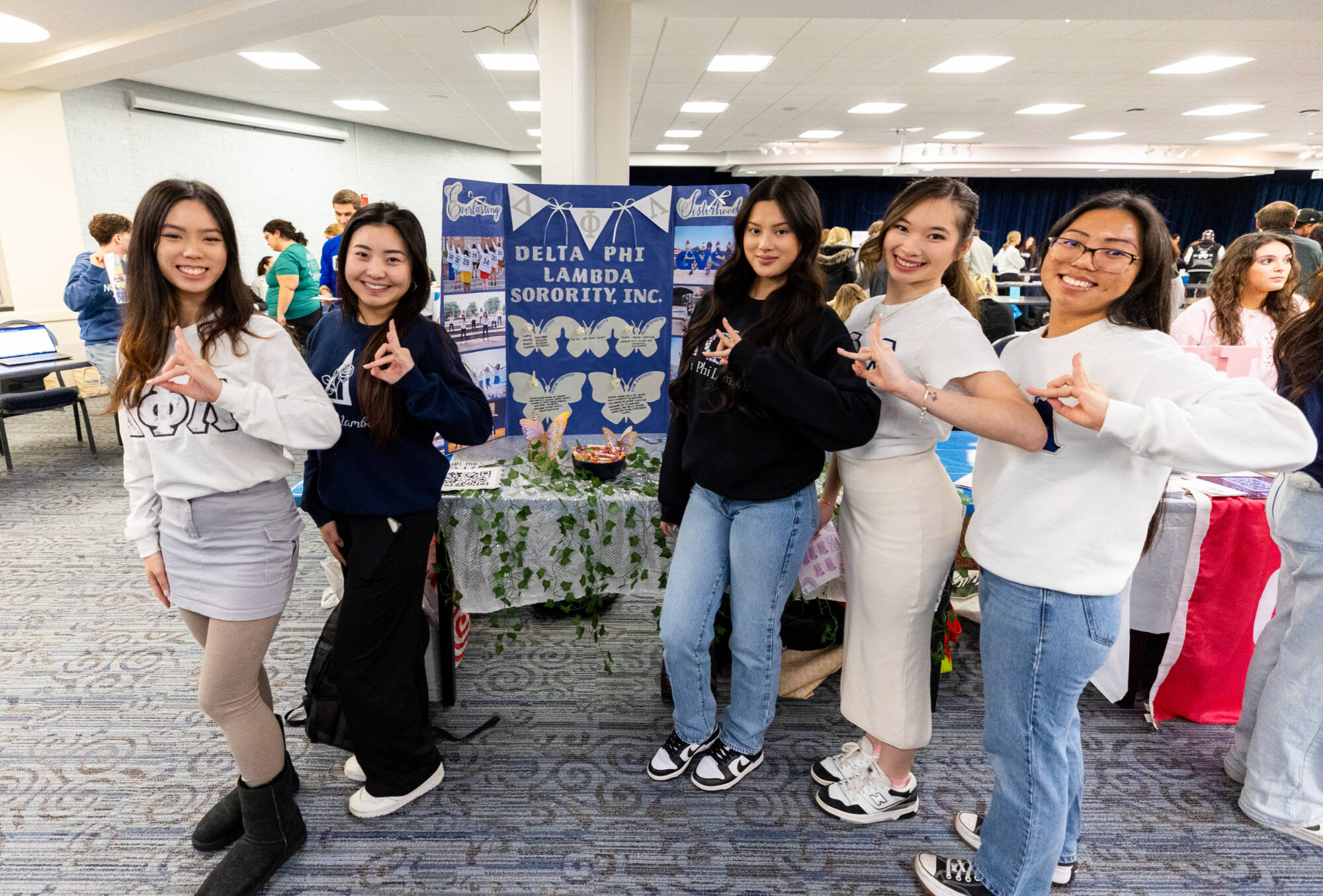 5 students posting with their organizations sign